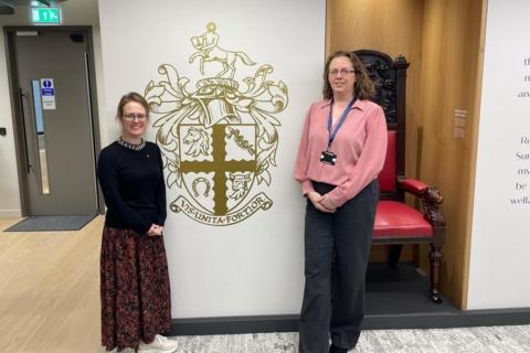 Angharad Belcher and Jenny Seward in front of the RCVS coat of arms