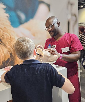 Man in scrubs speaks to young boy
