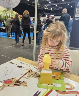 A little girl interactibg witj an activity at the RCVS stand at New Scientist Live 