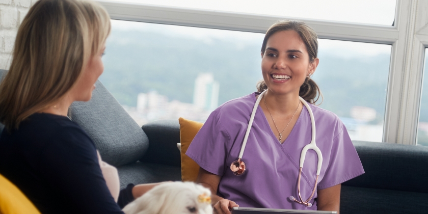 Vet sat on sofa with client