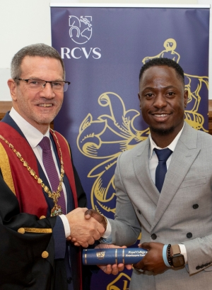Clement receiving his scroll and shaking hands with RCVS President Tim Parkin