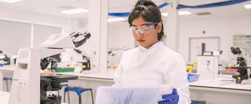  a vet student with a magnifier in the background