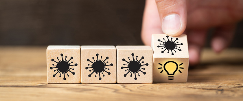 Wooden dice featuring images of virus and lightbulb