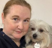 Josie Kirk holding a small, white dog