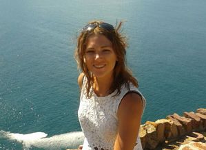 Lauren Valentine sitting in front of the sea on a sunny day