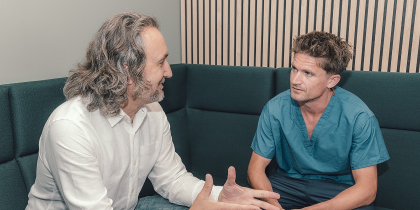 Two veterinary professionals sat chatting in a seating area