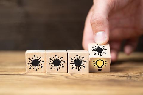 Wooden dice featuring images of virus and lightbulb