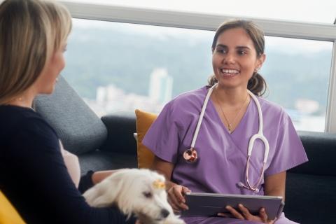 Vet sat with client on sofa