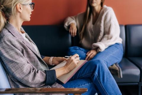 Two women sat chatting with notebooks