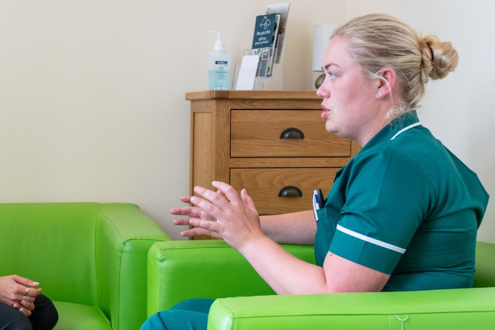 Veterinary nurse having a seated discussion with an unseen person