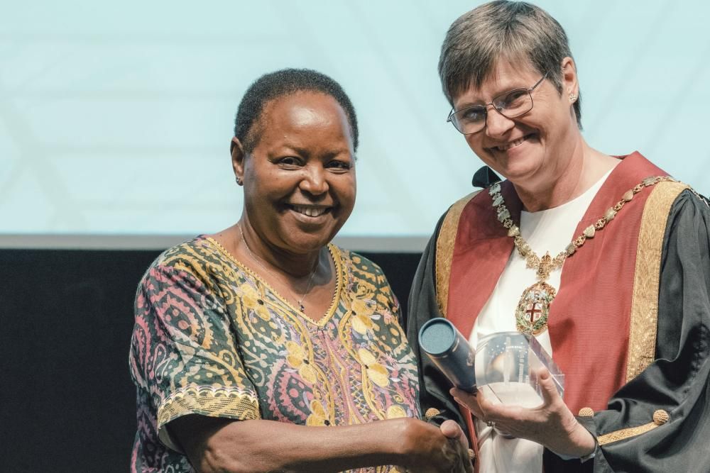 A woman smiling as she receives an award from a former RCVS President