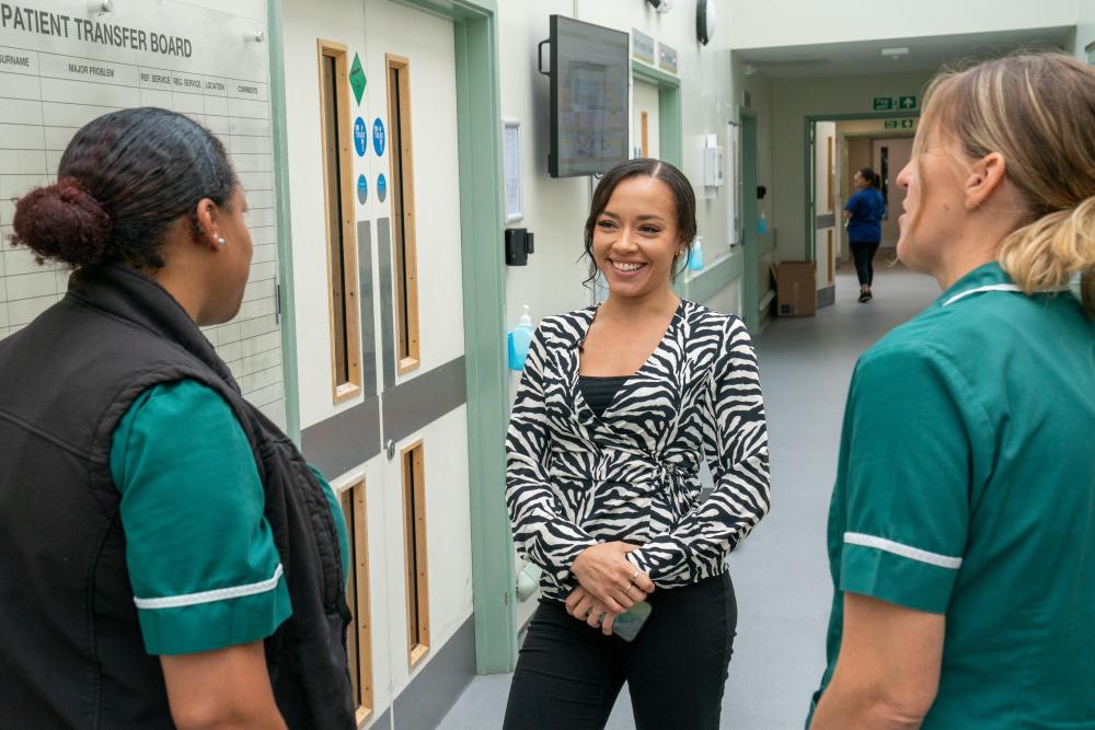 Practice staff converse in a corridor