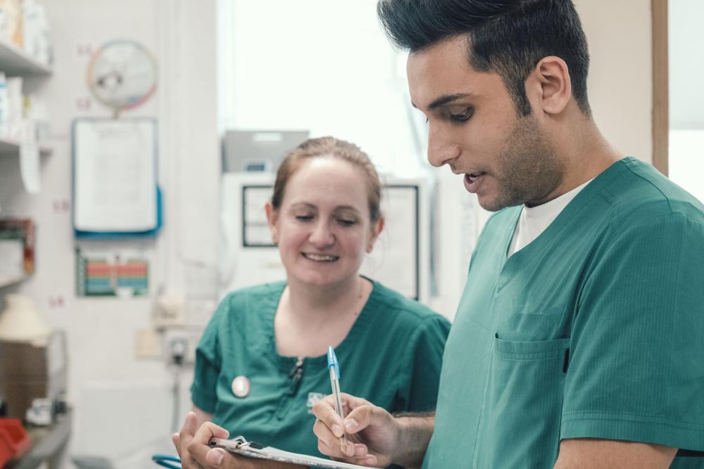 Two vet nurses in a veterinary practice entering infomration on a clipboard 