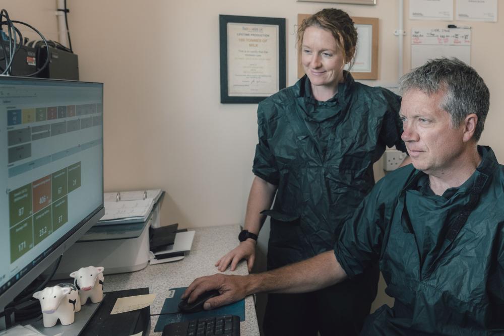 Two vets wearing personal protective equipment looking at a computer screen. 