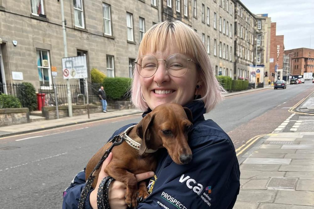 Ida Tomas holding a brown dachshund