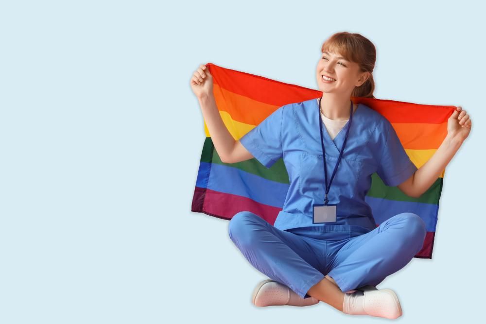 Person in blue scrubs holding a rainbow flag.