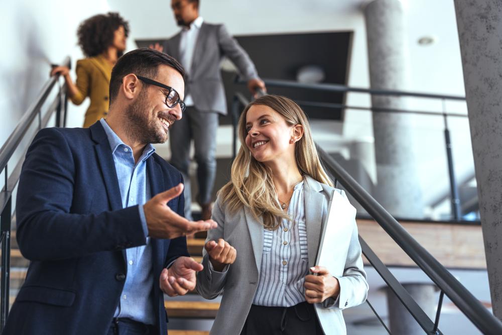 Photograph showing business professionals networking on a modern office staircase. 